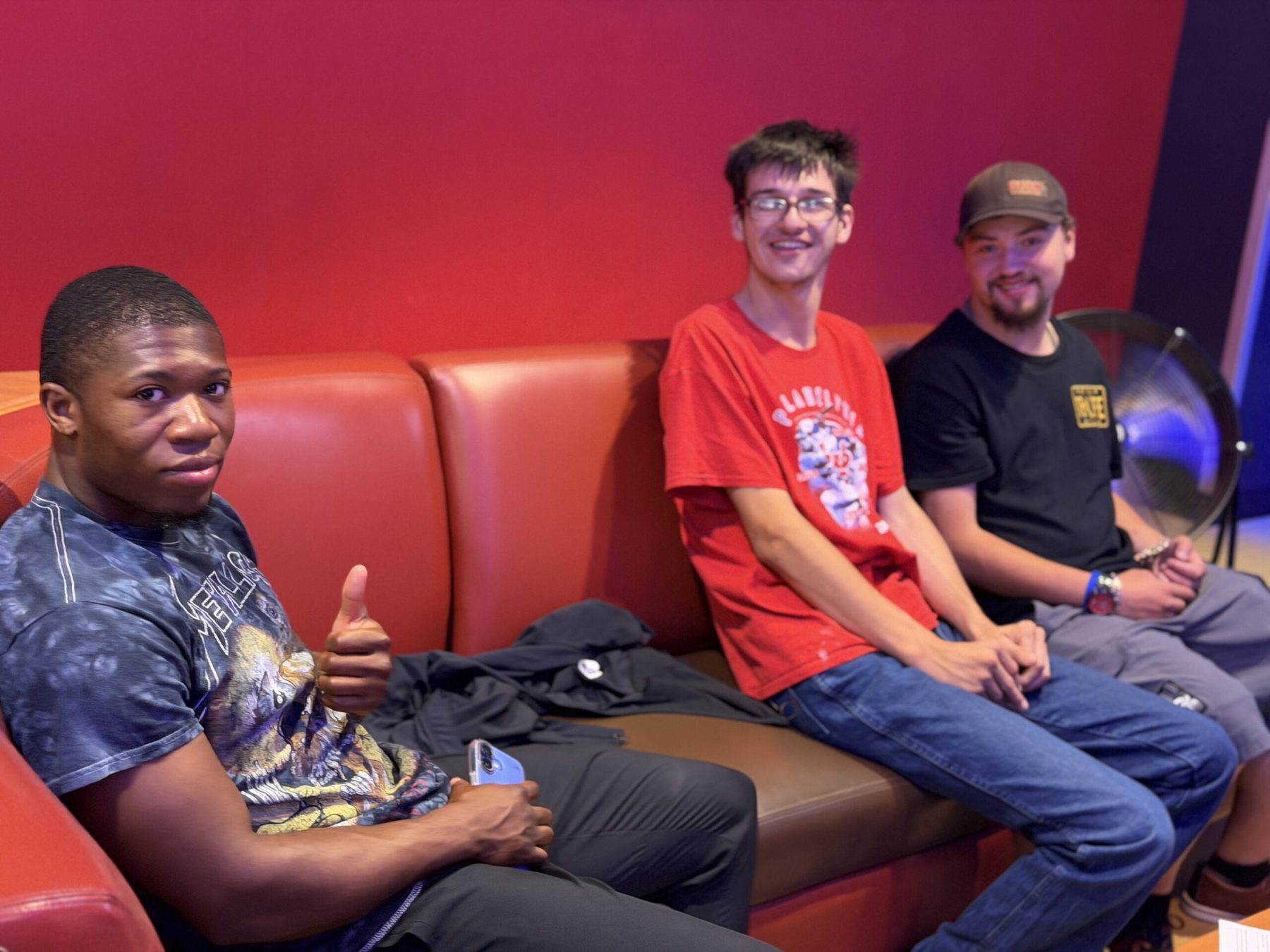 Three friends relaxing together at a bowling alley