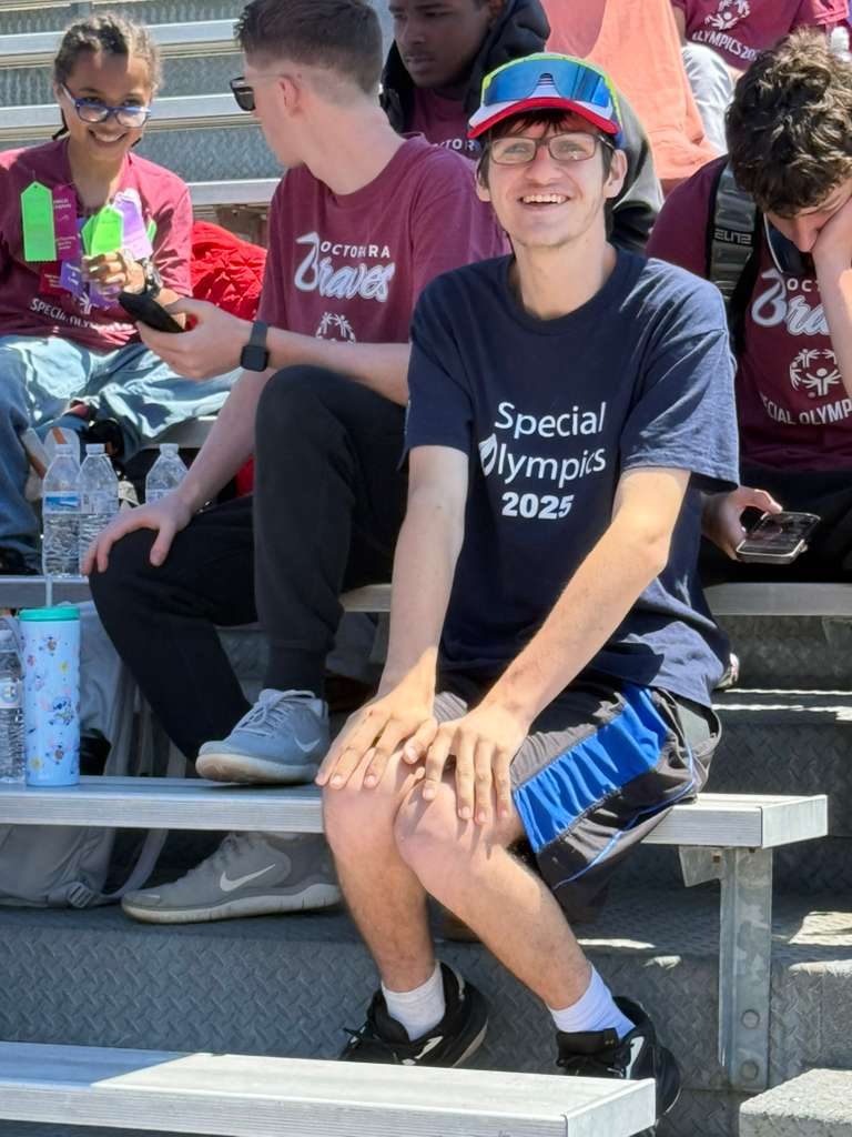 Friends cheering from the stands at a Special Olympics event